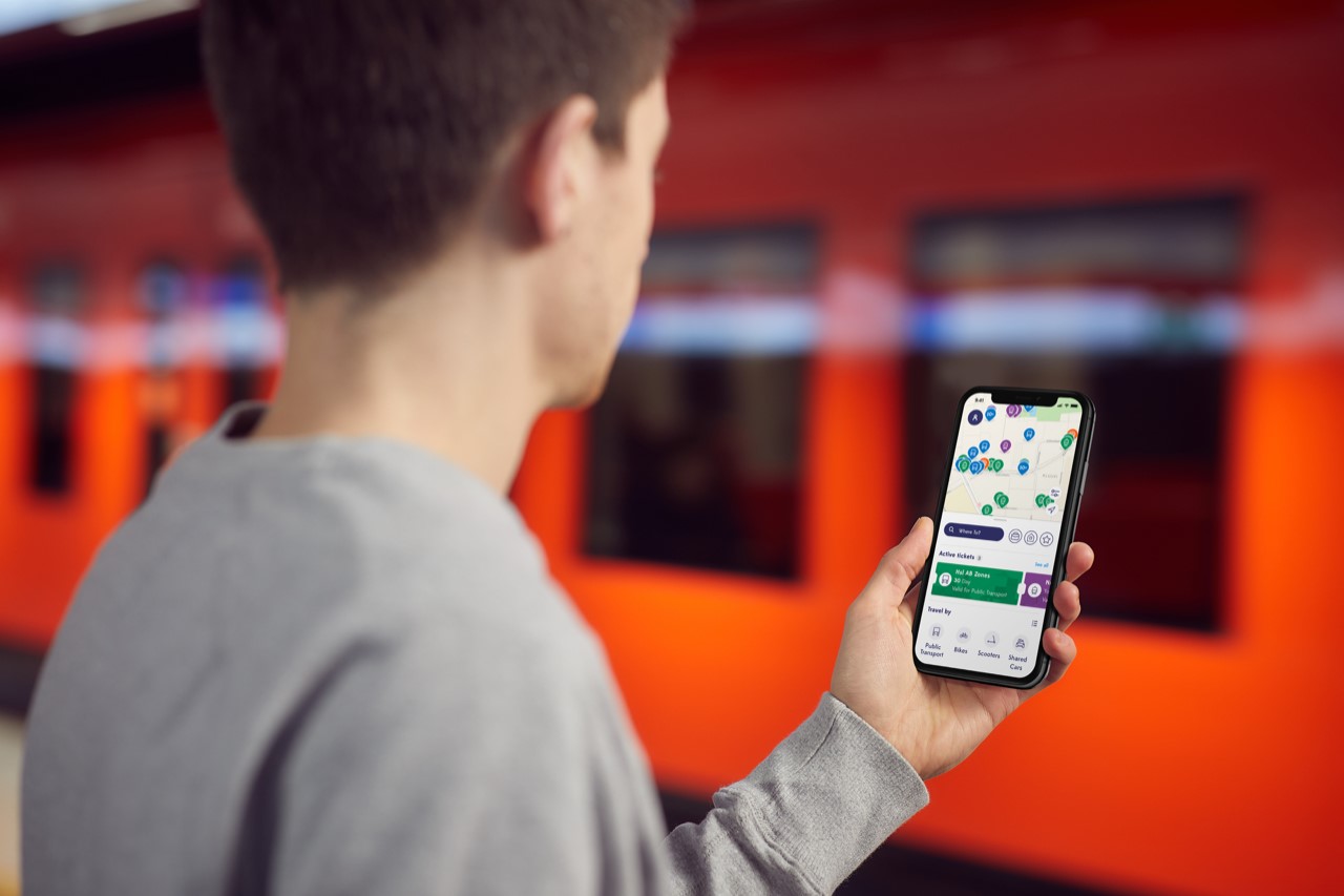Una persona que usa una aplicación MaaS en un teléfono. 