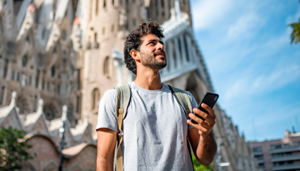Hombre planificando un viaje Madrid-Barcelona con un móvil 
