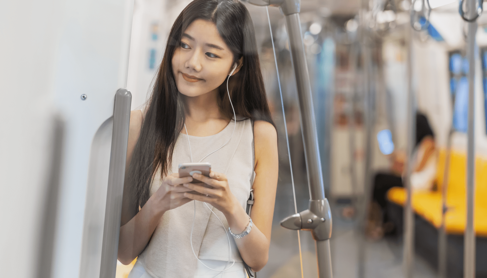 Joven escucha música y utiliza el móvil mientras viaja en autobús.