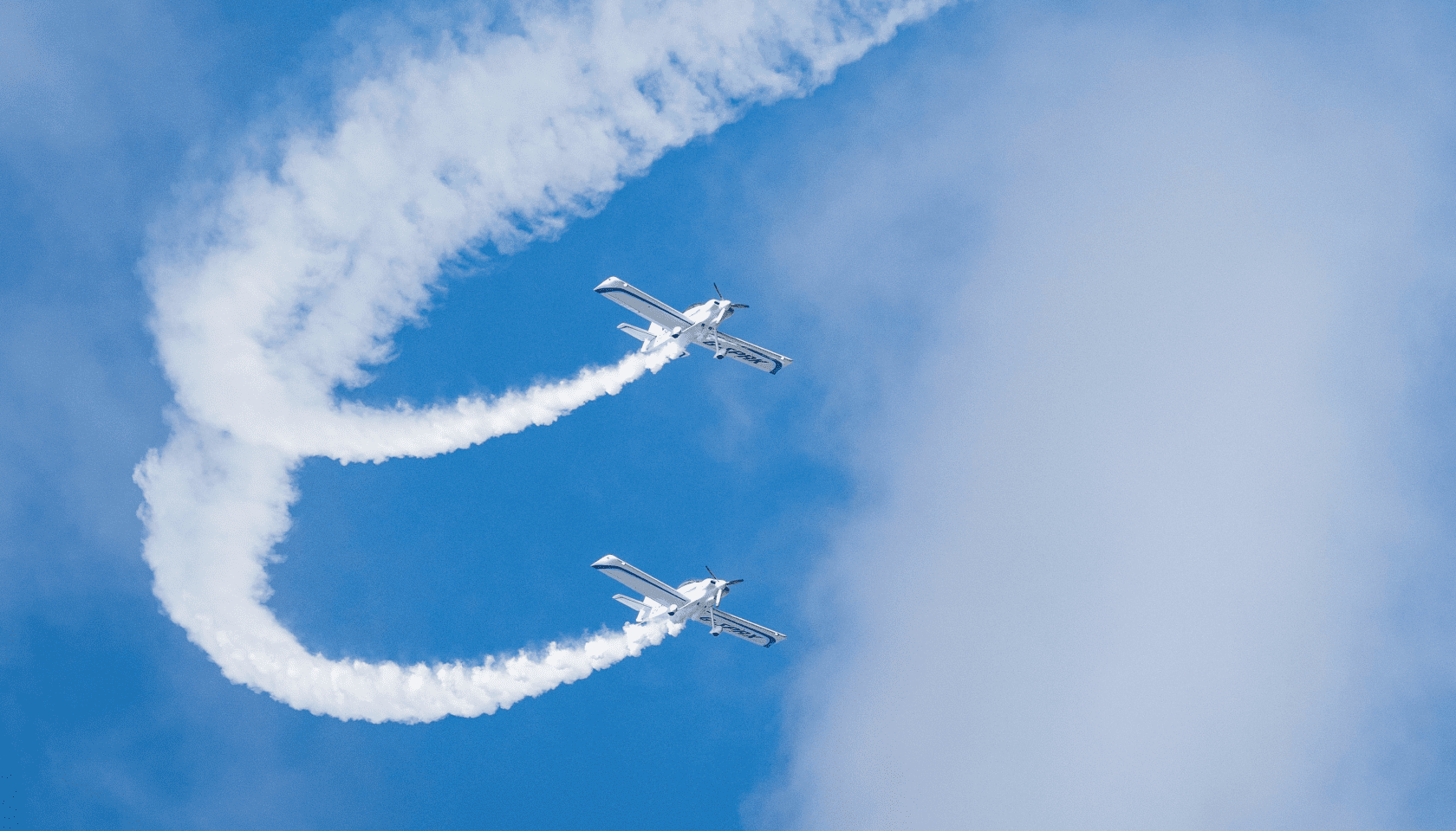 Dos aviones realizan una acrobacia aérea dejando el trazo dibujado en el cielo.