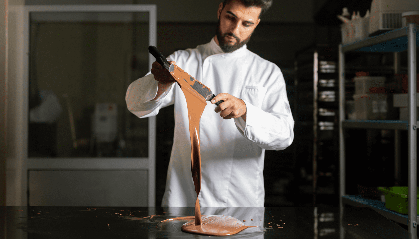 Hombre trabaja el chocolate fundido en la cocina de un restaurante.