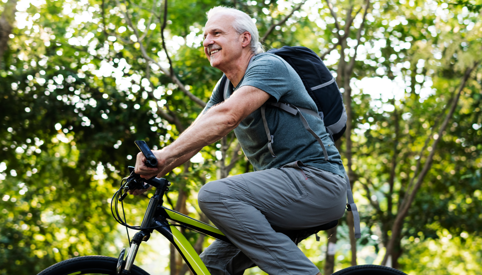 Persona mayor pasea en bicicleta para reducir la huella de carbono.